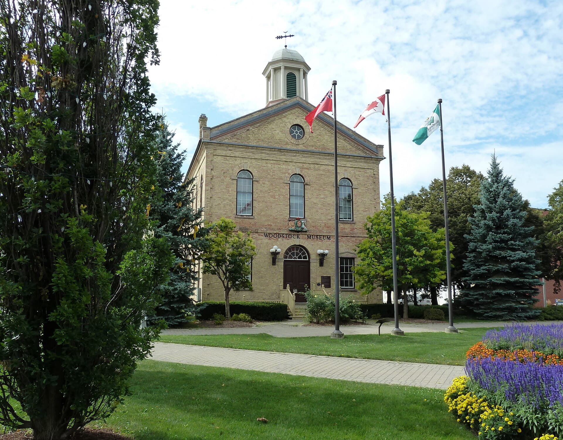 The old town hall, now the Woodstock Museum, with its cupola and flags on the downtown square
